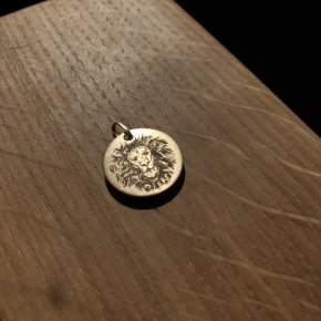 Gravure lion sur médaille or
